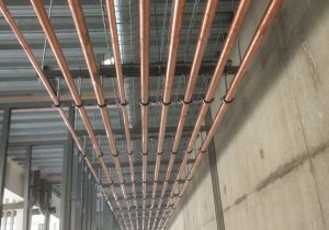 Commercial plumbing showing copper pipes in roof of building